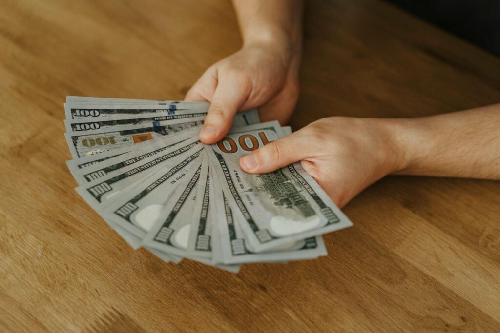 A person holds a bundle of cash.