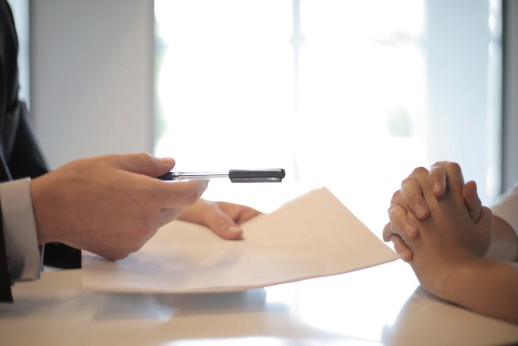 Two men engaged in a serious discussion, one holding a pen and a contract