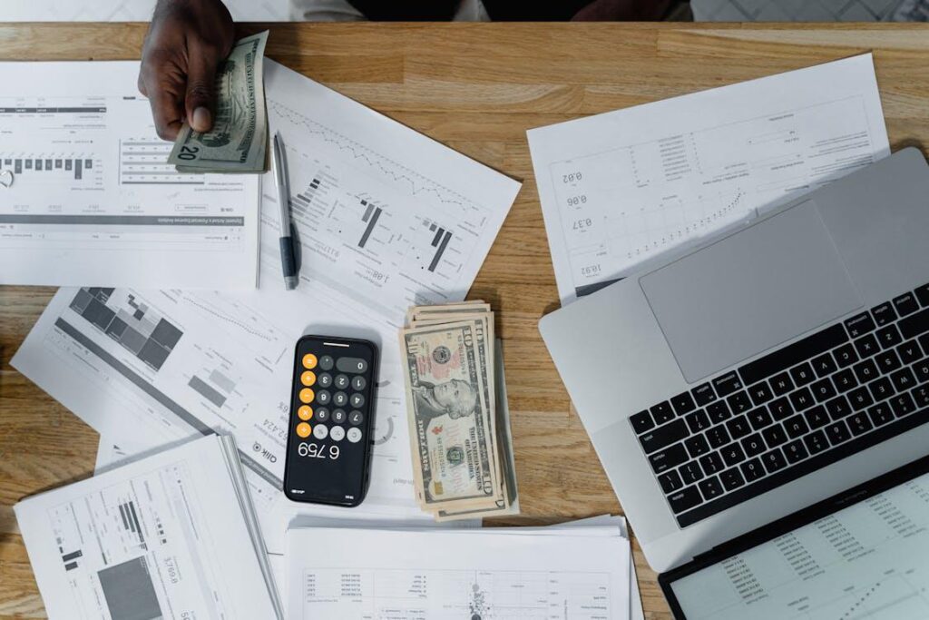 A wad of cash sitting next to a calculator.