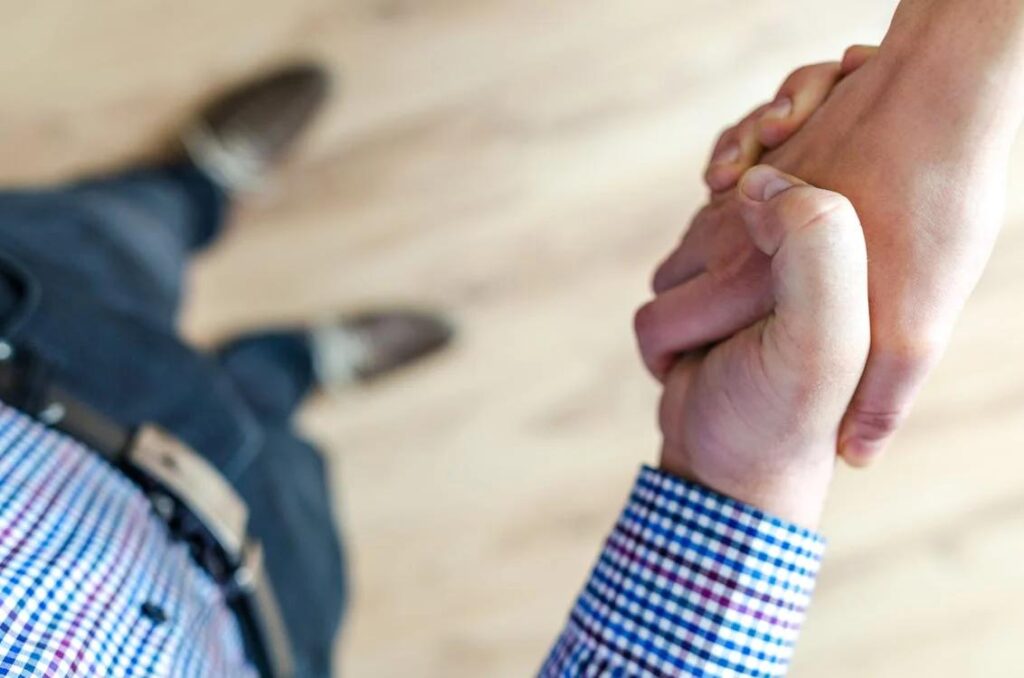 A handshake between two individuals in a real estate office