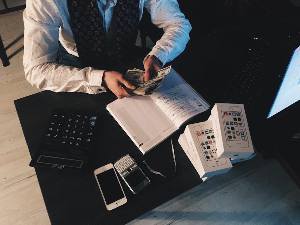 an accountant counting U.S. dollar bills at a desk, symbolizing financial expertise in hard money lending in California