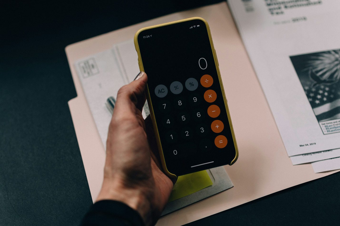 A person holding a phone calculator. 