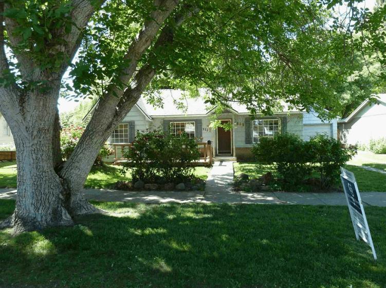 A house with green grass and trees.