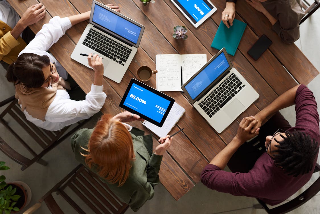 A table with several people sitting with their laptops.