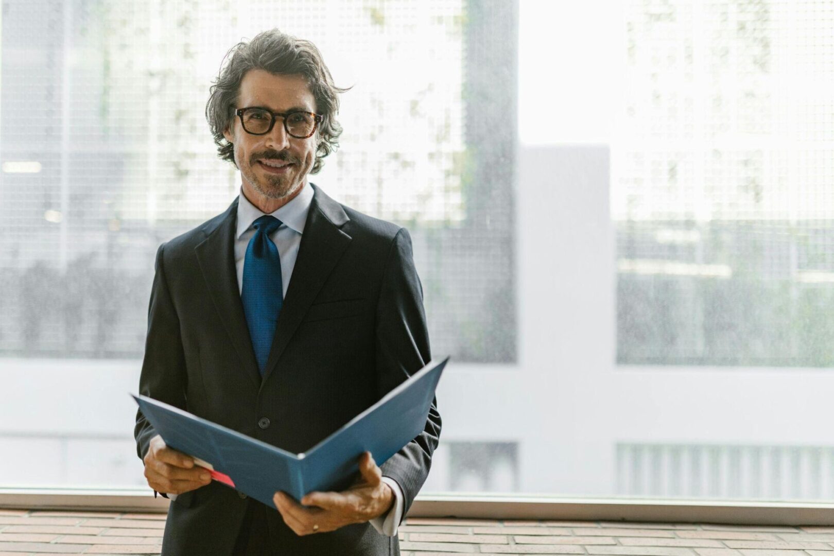 A man in a suit holding a file