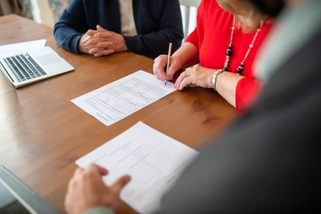 A person signing document on the table.