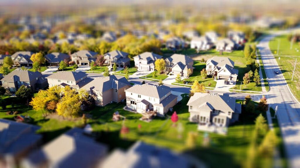 a high-angle view of a suburban neighborhood with houses and green yards