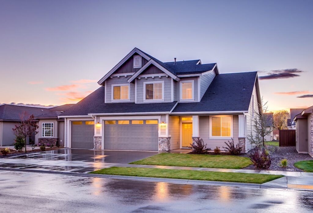 A blue and gray concrete house with an attic at twilight, representing real estate properties ready for renovation.