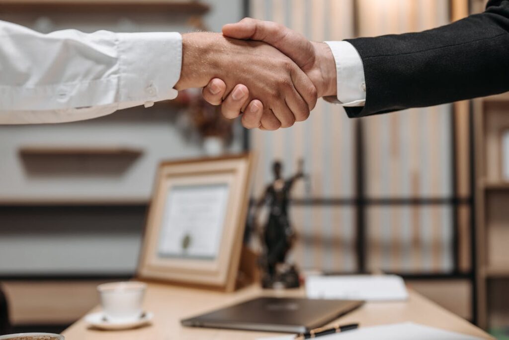 A close-up of people shaking hands, symbolizing agreements and partnerships in real estate investments.