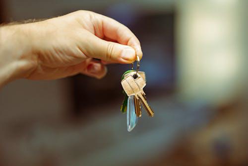 A person holding house keys, symbolizing property acquisition enabled by hard money lending.