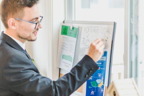 A person working on a board with financial documents, representing the meticulous process of securing hard money loans for real estate projects.