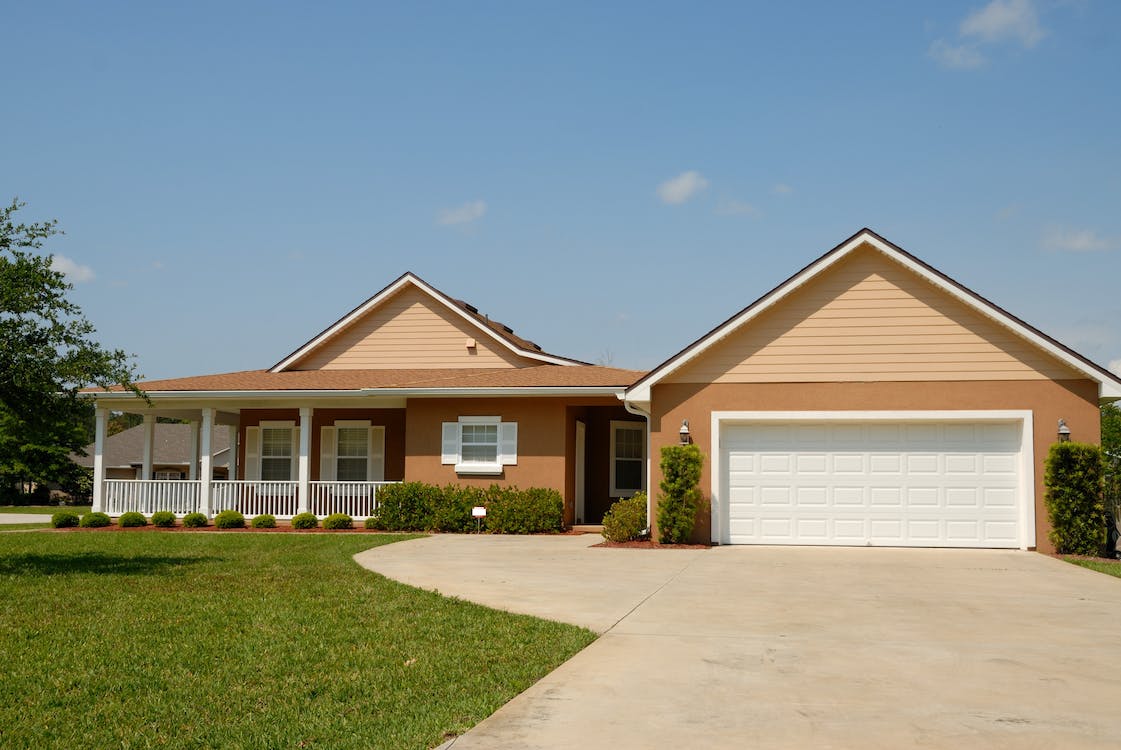 A white roll-up door and a driveway