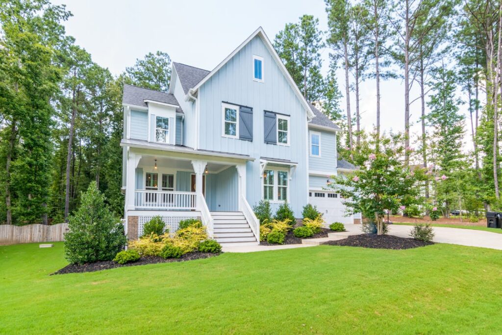 A blue house on a lush green lawn, representing a potential investment property in Texas.