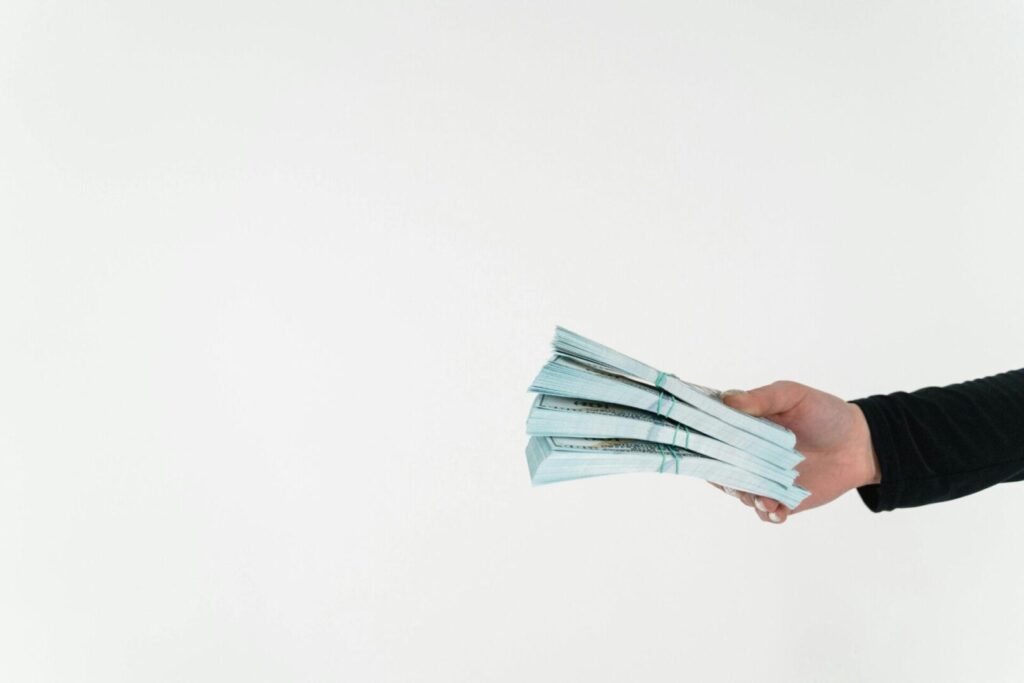 A person holding stacks of cash