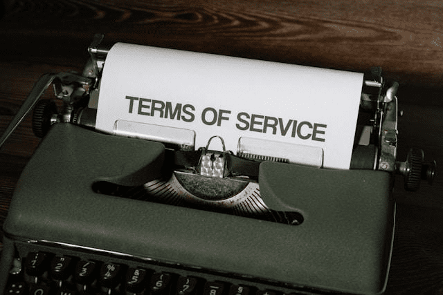 A typewriter and paper with terms of service written on it.