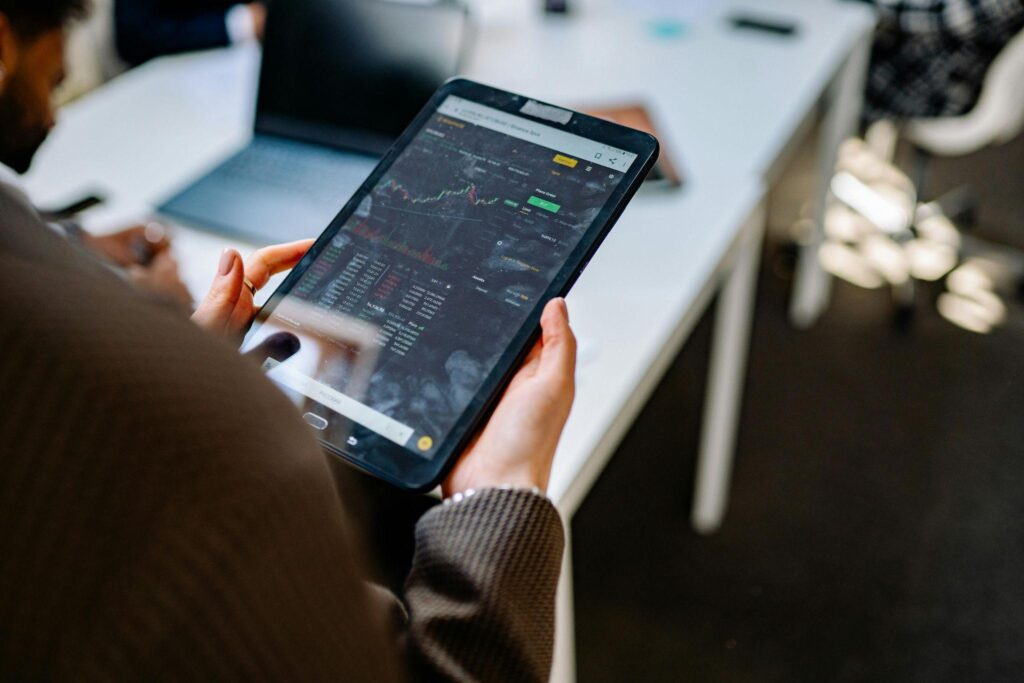 Man holding a tablet displaying real estate financing data.