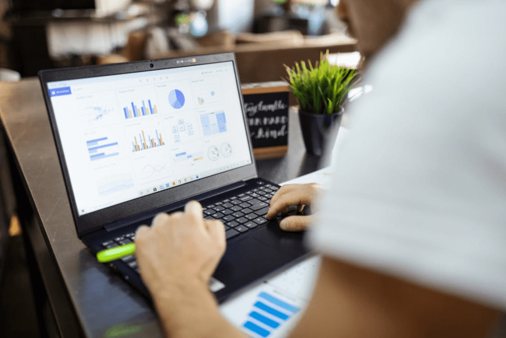 A person using a black and gray laptop, researching real estate development loans and financing options in Texas