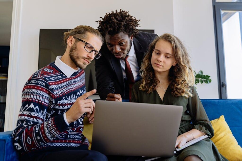 a person explaining something to a couple on a laptop