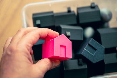 Red and black model houses representing multi-family property investment potential.