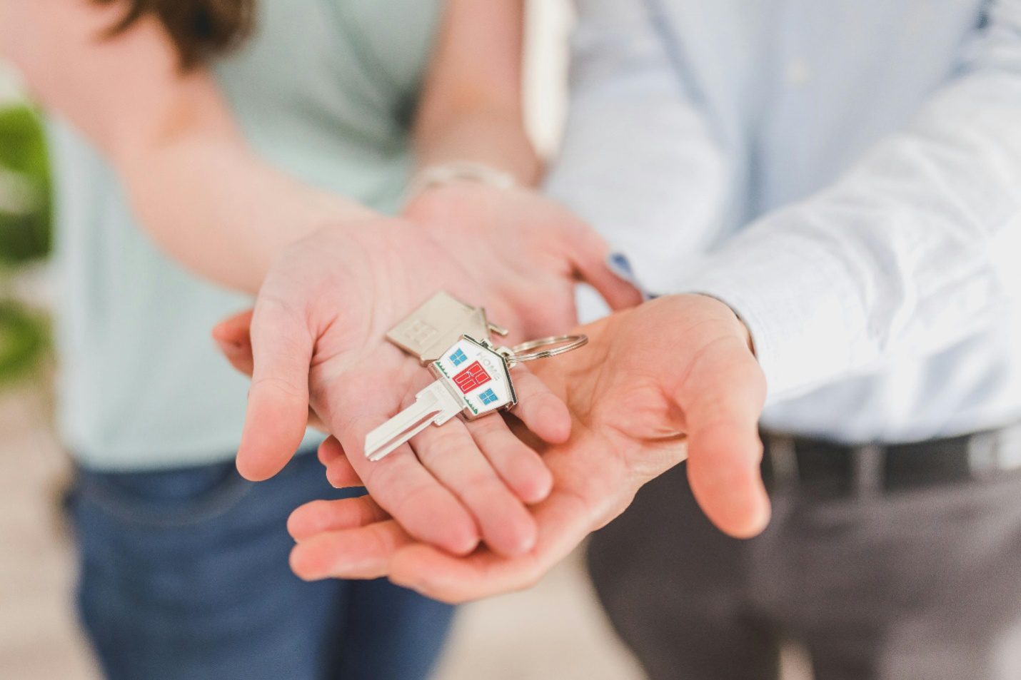 two people holding house keys