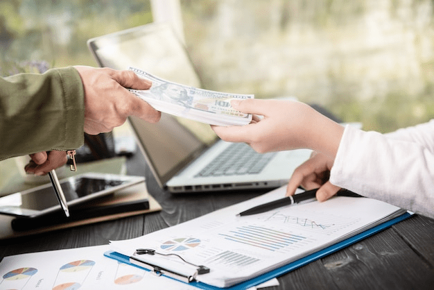 A person handing over cash, symbolizing hidden costs in cash-out refinancing.
