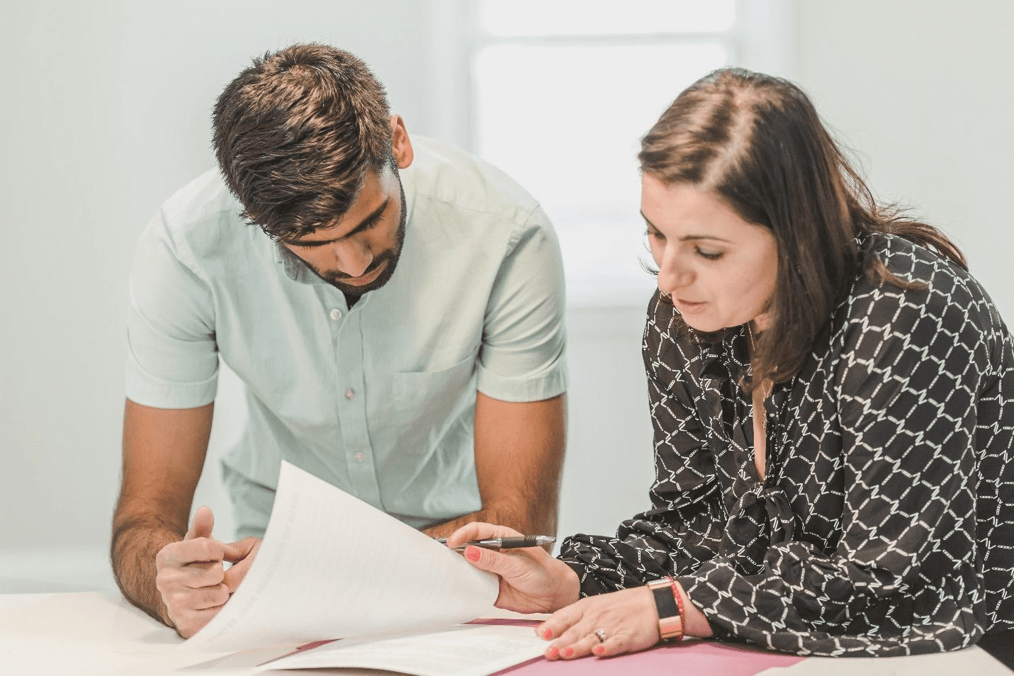 A picture of two people looking at documents