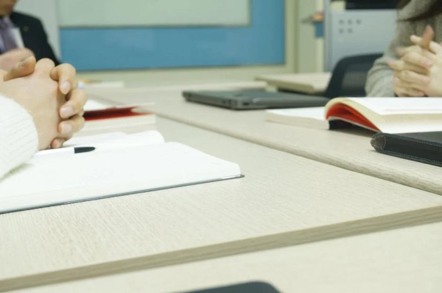 An image of people sitting at a table with open books