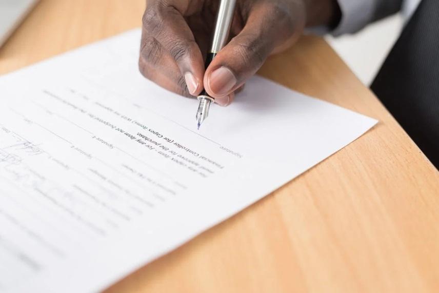 An image of a person signing a document