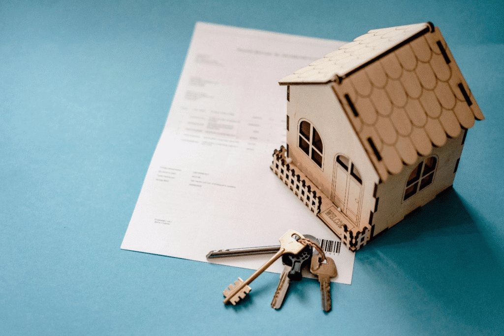 A picture of a paper, a house model and keys