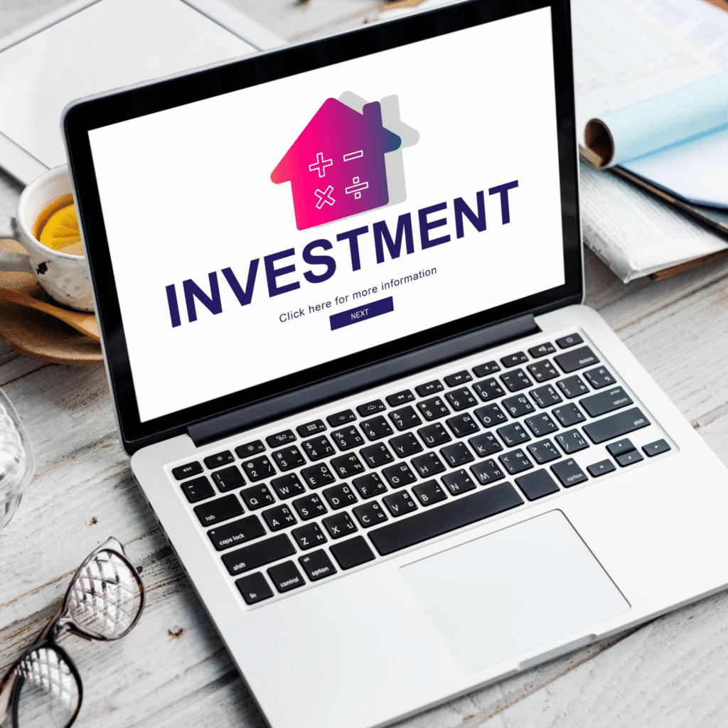 A laptop screen displaying "Investment" in bold text.