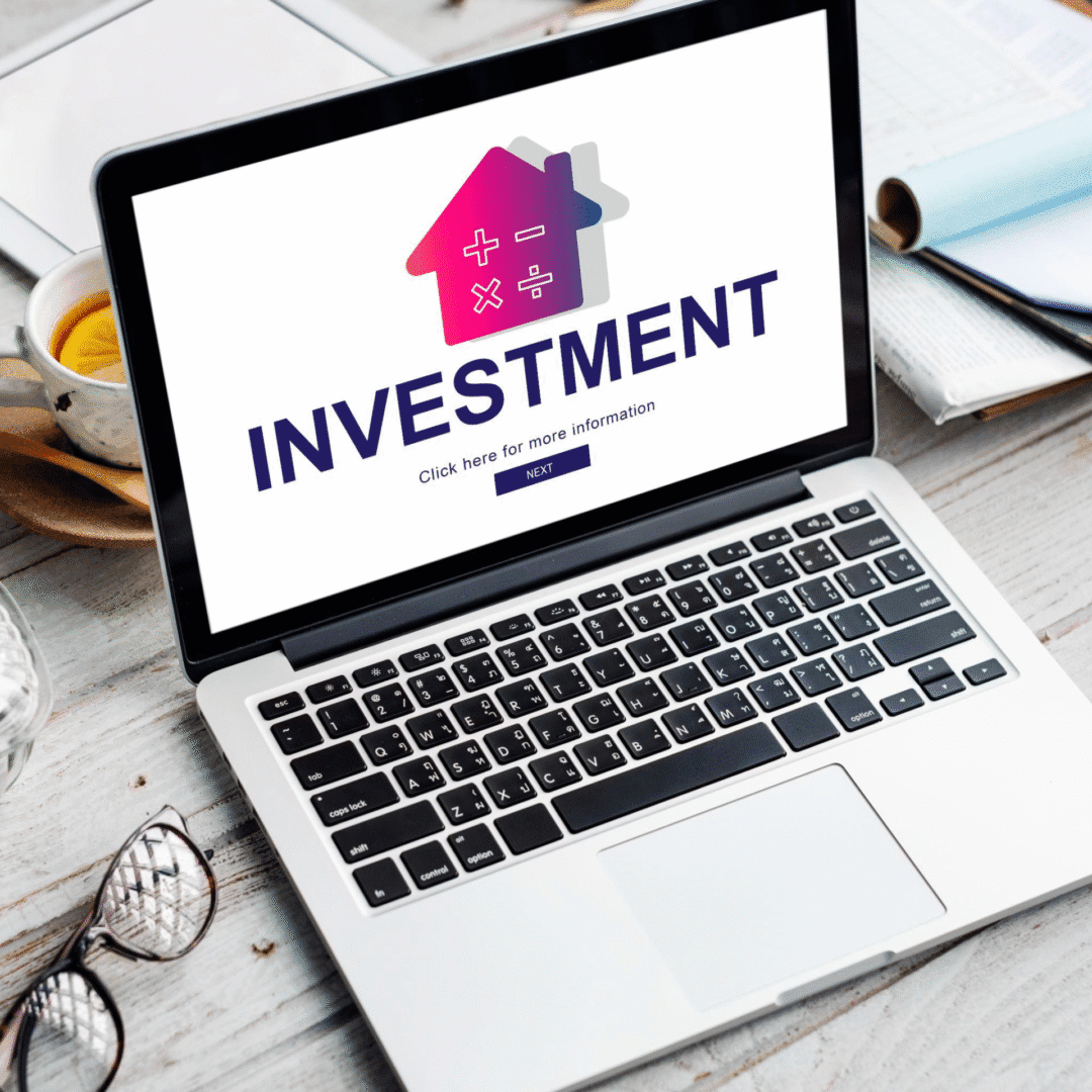 A laptop screen displaying "Investment" in bold text.