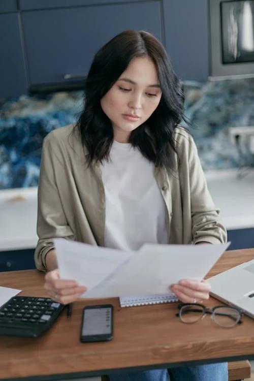 A person reviewing financial documents and credit reports.