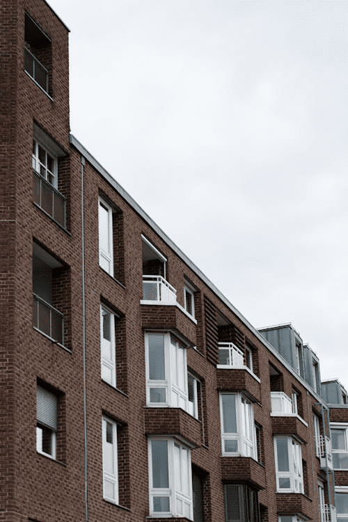 A modern micro-apartment building with multiple balconies in an urban setting.