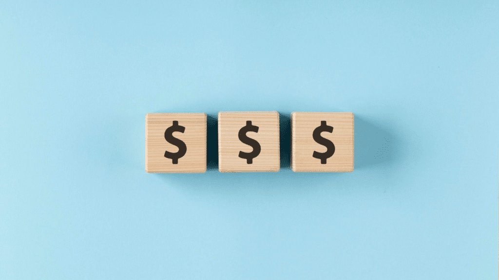 Three wooden cubes with dollar signs 