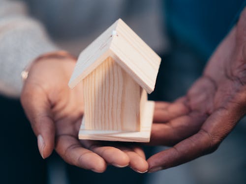 Investor holding a miniature house model representing a short-term rental property opportunity.