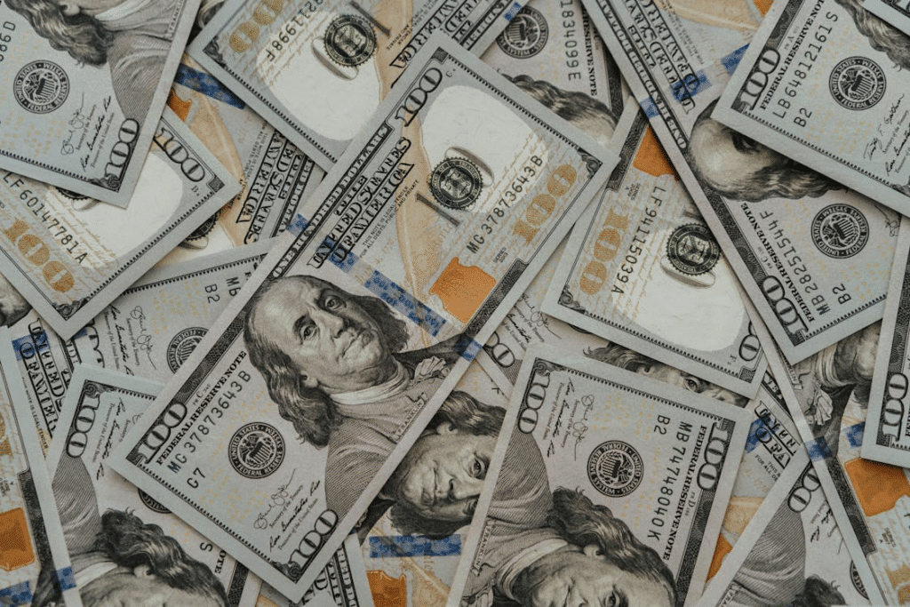 A spread of $100 bills covering the entire frame.