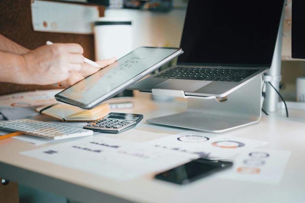 Laptop and calculator on a desk used for analyzing risk-adjusted real estate loans