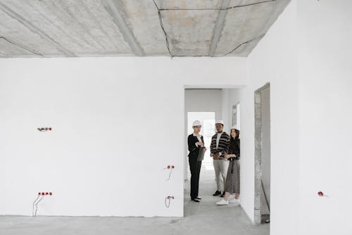 Three people examining a property under construction