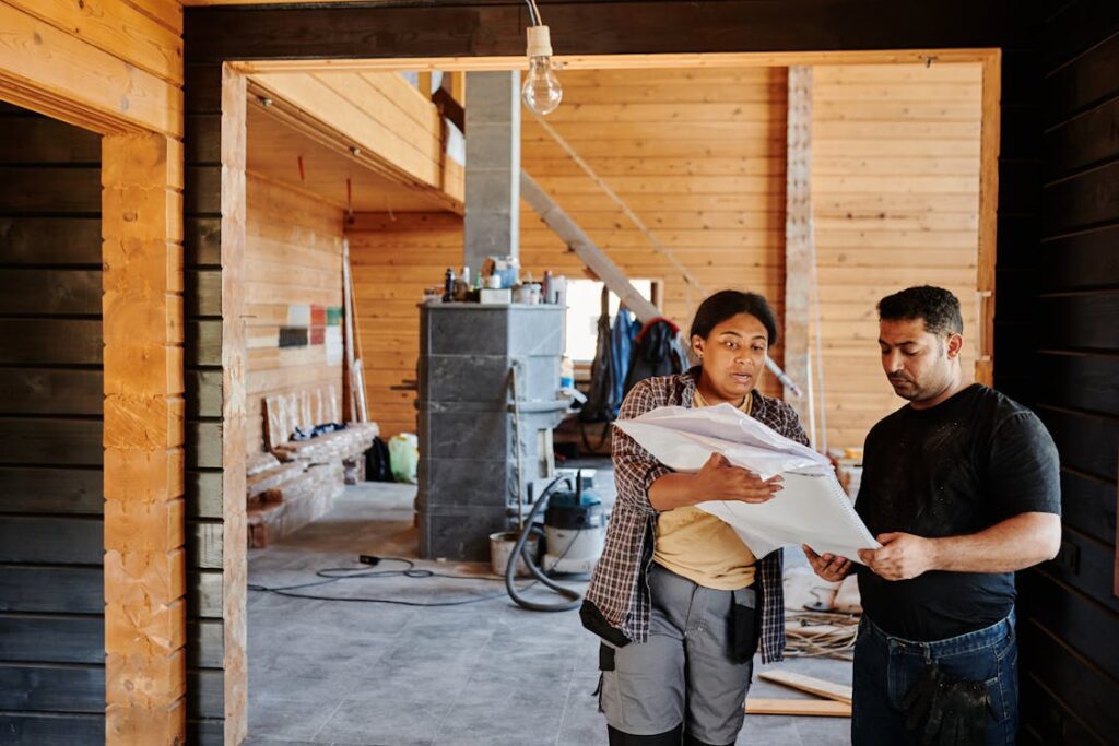 A male and female worker examining a construction plan at a site
