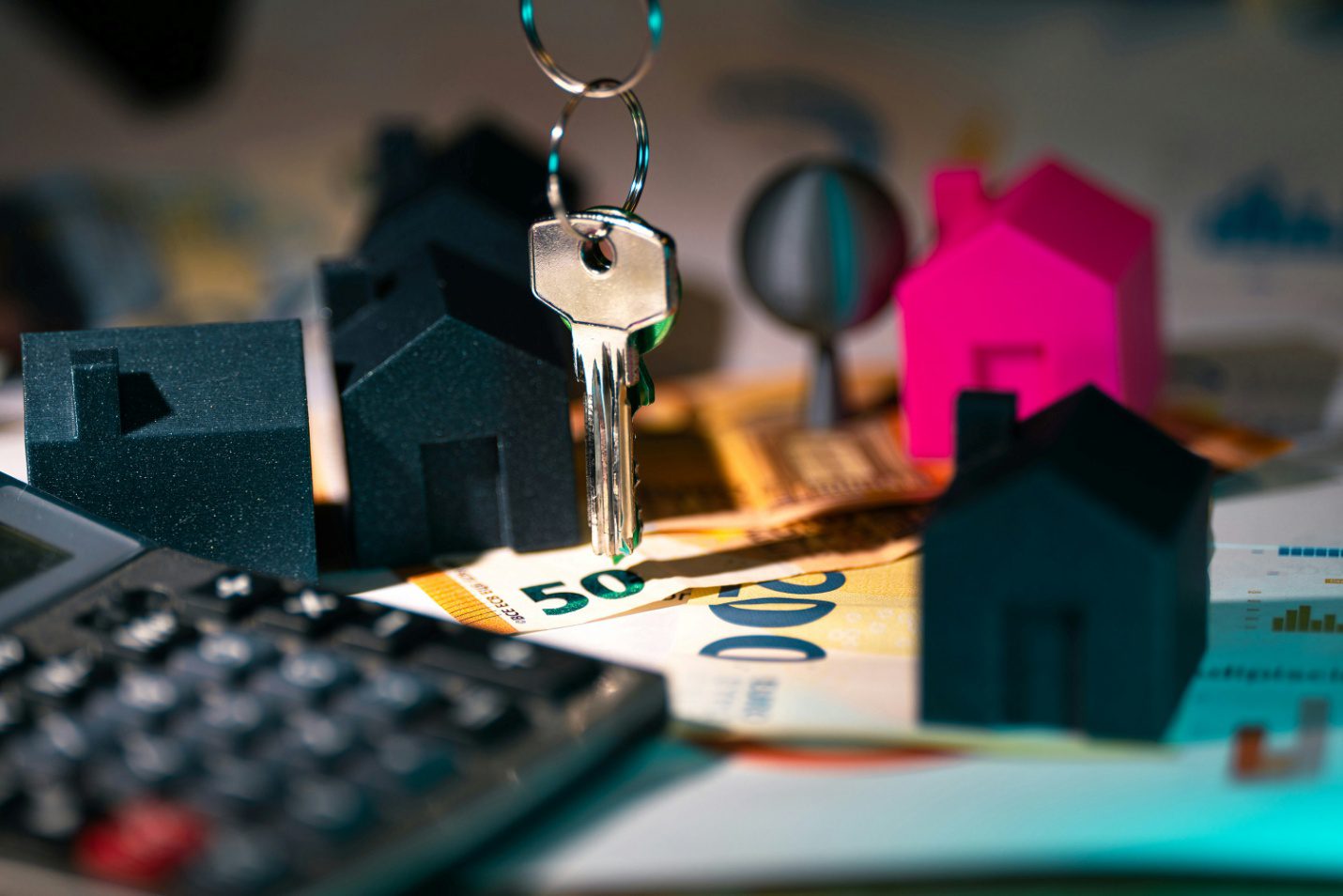 silver key hanging between miniature houses