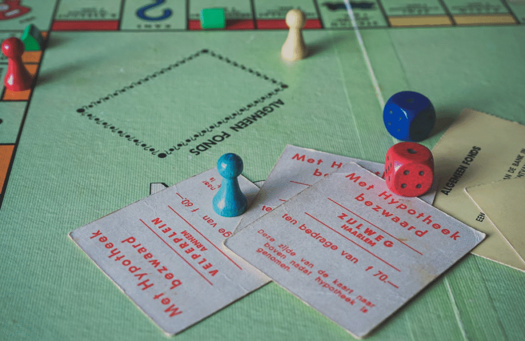 A close-up of a Monopoly board game with game pieces, cards in Dutch, and dice.