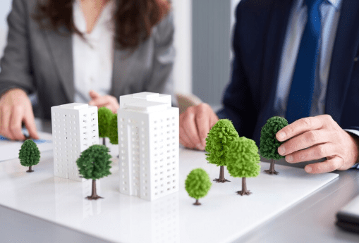 A woman and a man looking at a miniature model