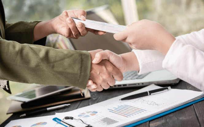 Professionals finalizing a commercial loan agreement with a handshake