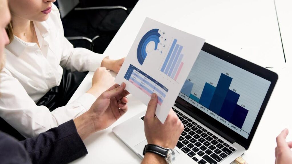 A person holding a paper in front of laptop