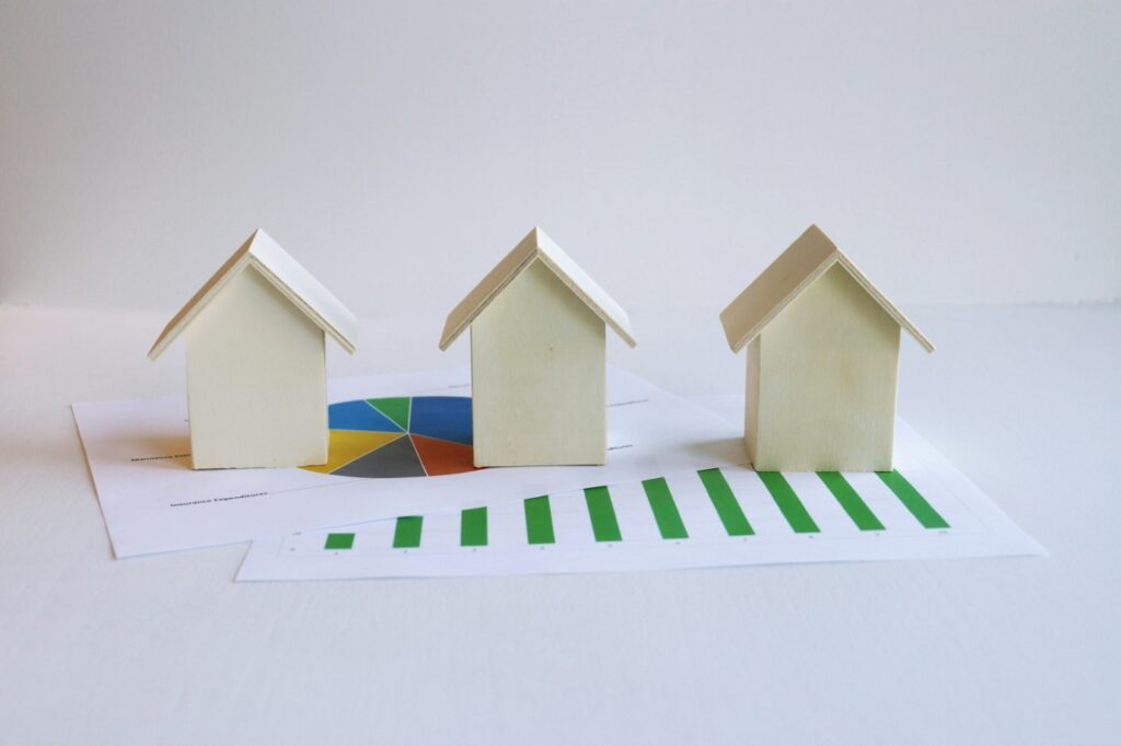 house-shaped figurines placed atop financial documents