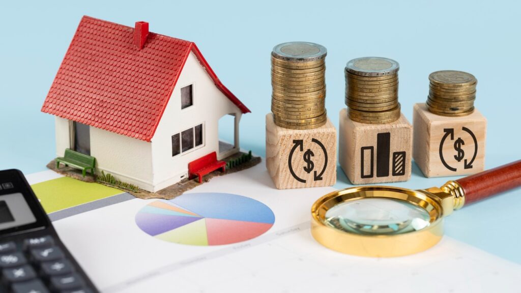 coins, magnifying glass and a house figurine on a white table