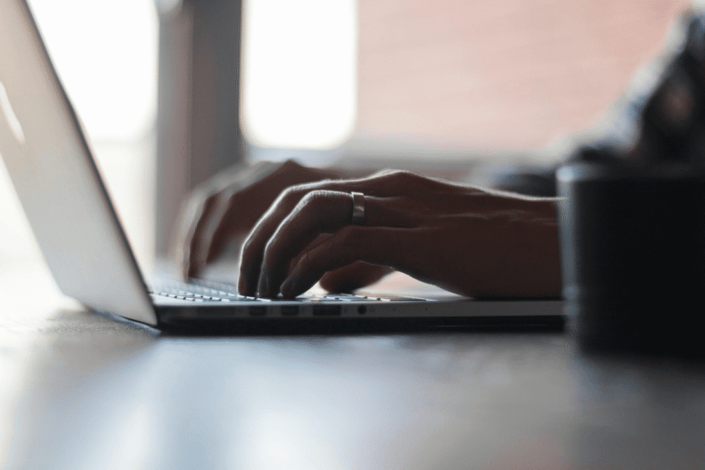 A person using a laptop on a table.