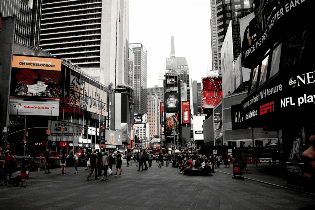People walking past buildings on a city street with residential and commercial spaces