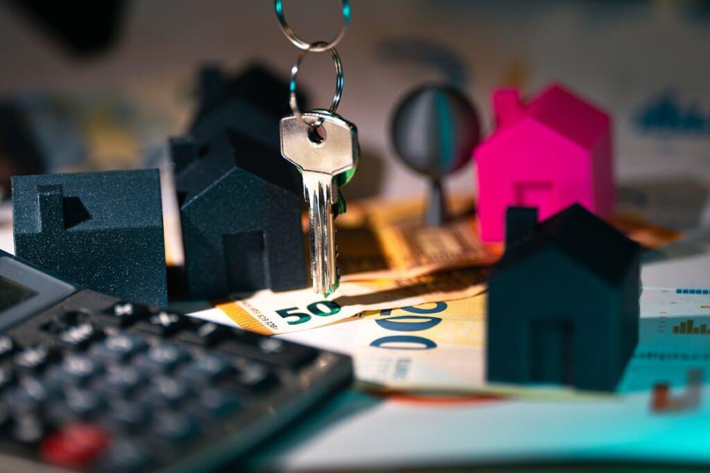 4 black and 1 pink model houses can be seen with a key, money, and a calculator