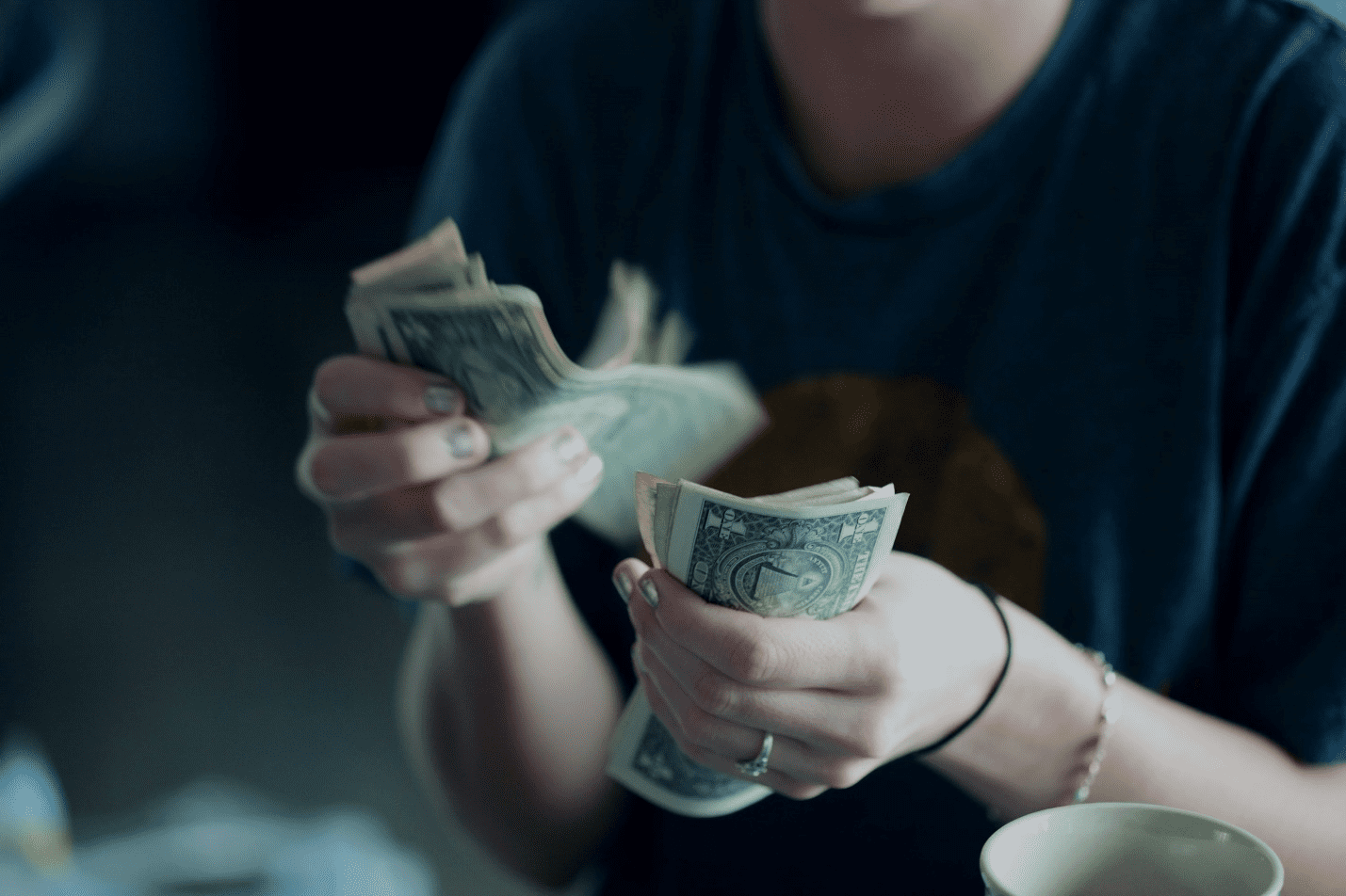 A person counting money in their hands.